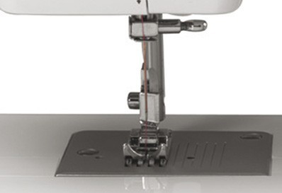 Primer plano de una aguja e hilo de máquina de coser. La aguja está en posición baja.