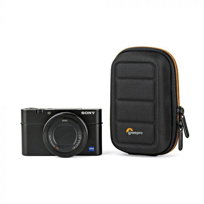 Schwarze Sony-Kamera mit Etui, beides auf weißem Hintergrund. Kamera hat Objektiv und Knöpfe. Etui ist schwarz.