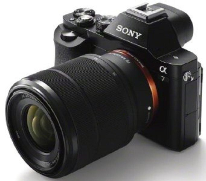 Cámara Sony Alpha 7 negra con lente. La cámara está sobre una superficie blanca, vista en ángulo.
