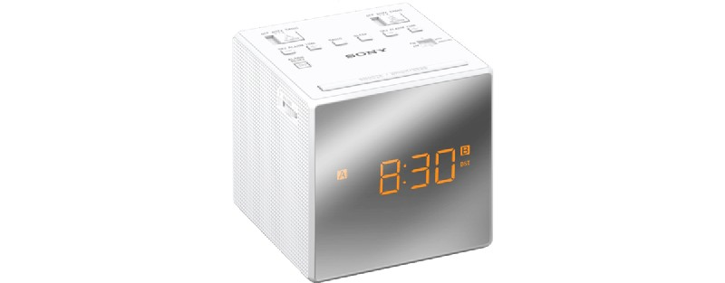 Despertador cúbico Sony blanco. Muestra 8:30 AM con números digitales naranjas.