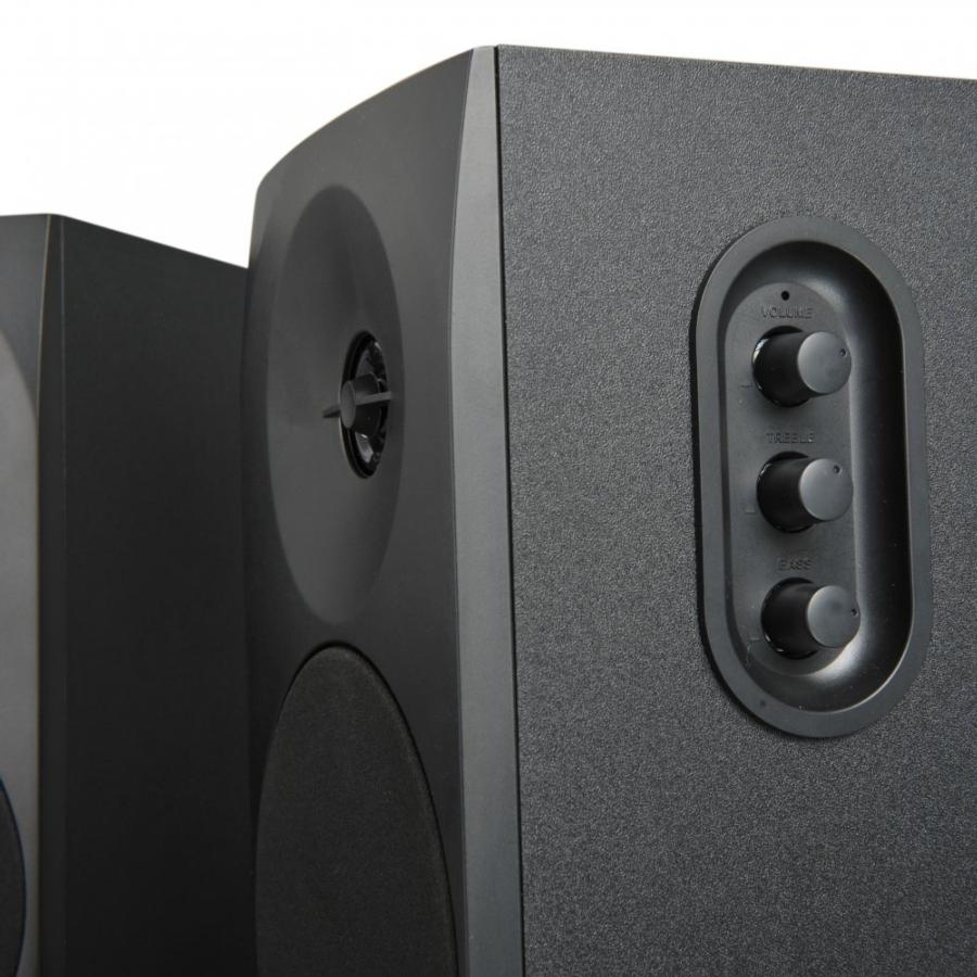 Un par de altavoces negros. Un altavoz tiene perillas de volumen, agudos y graves. El otro está en la parte trasera.