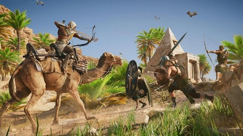 Una escena de acción de un videojuego con guerreros luchando en un entorno desértico.
