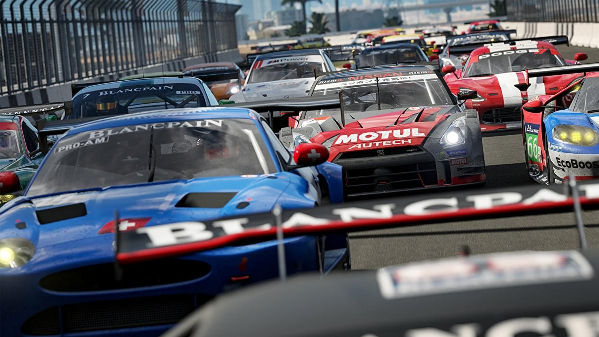 Coches de carreras en una pista. Coches azules, rojos y blancos corriendo, con el coche líder con el logo Blancpain.