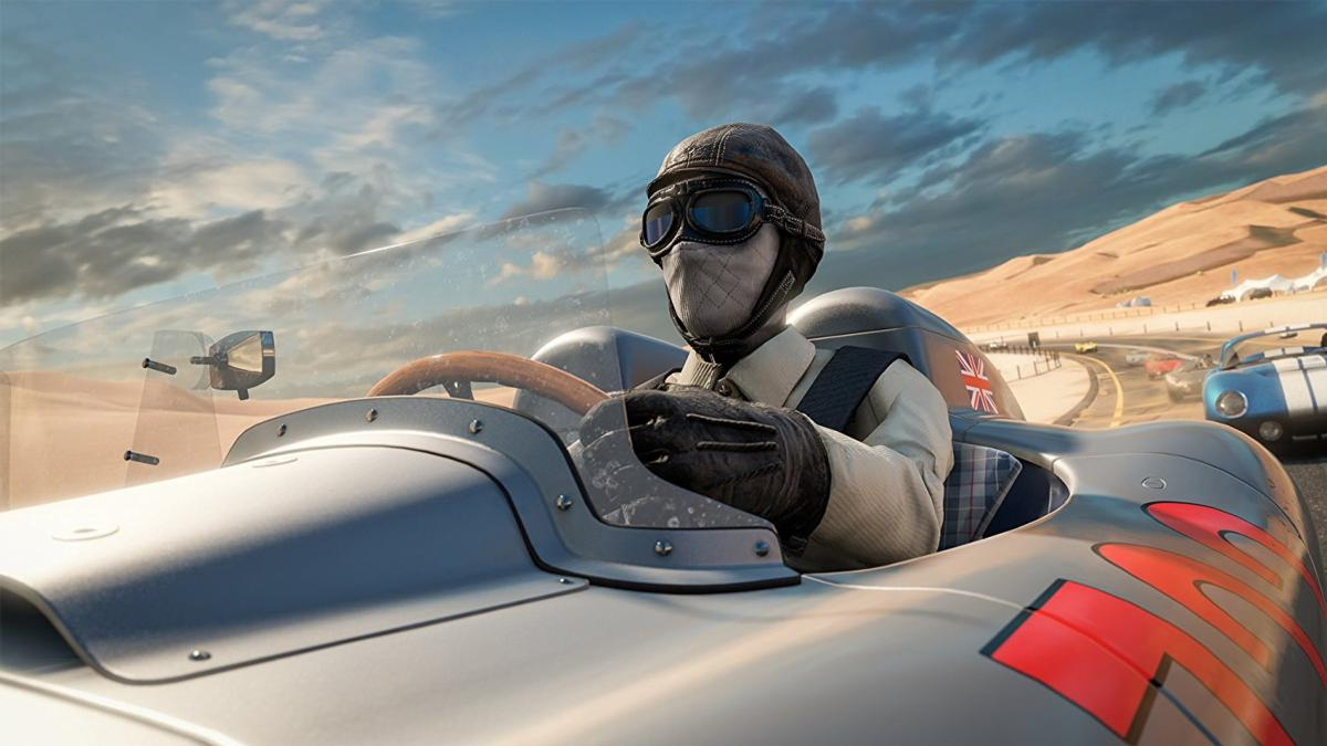 Un piloto con equipo de carreras vintage está sentado en un coche de carreras plateado. El fondo muestra un paisaje desértico y otros coches en una pista.