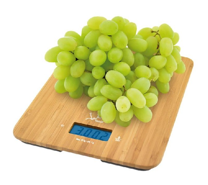 Uvas verdes en una báscula de madera, mostrando 3.002. La báscula tiene una pantalla digital.