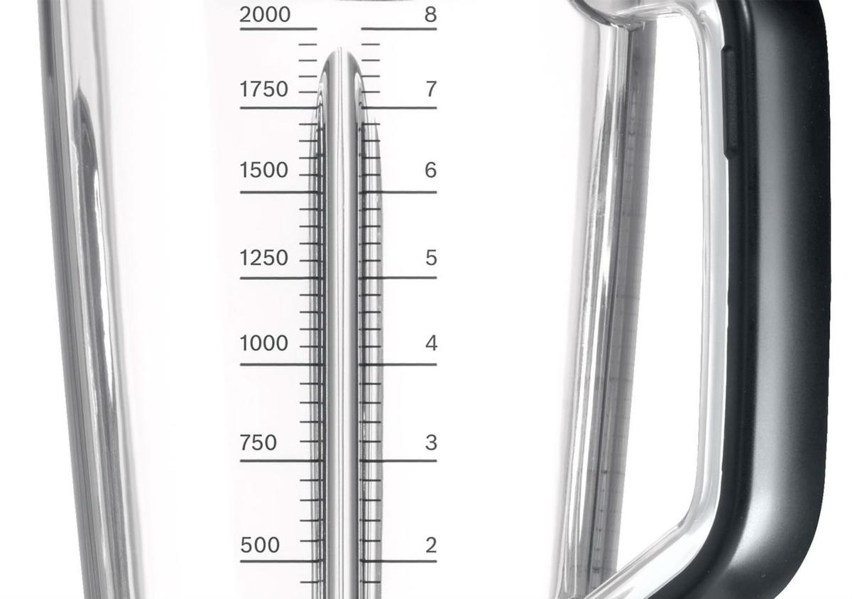 Primer plano de la jarra de plástico transparente de una licuadora con marcas de volumen de 500 a 2000 ml.