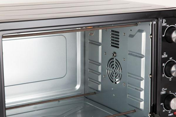 Interior de un horno negro con ventilador y elementos calefactores visibles. Interior vacío.