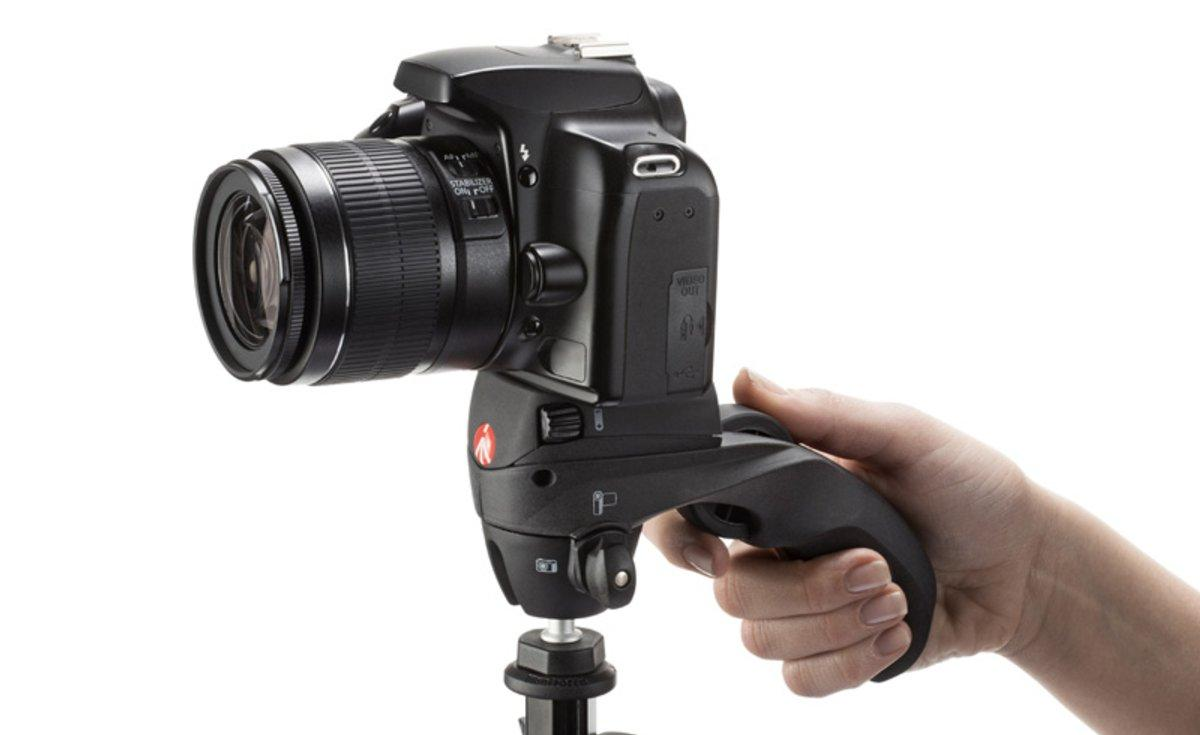 Una cámara DSLR sujeta a un mango Manfrotto. Una mano sostiene el mango.