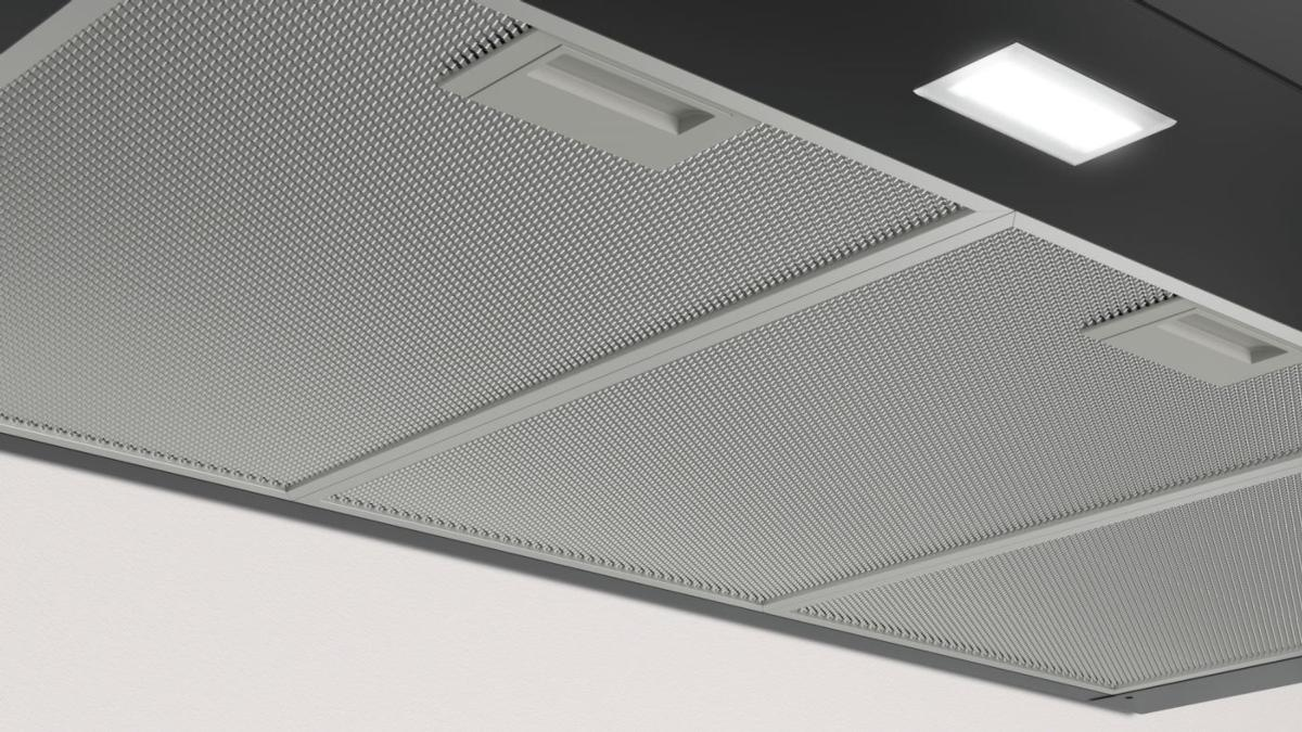 Vista inferior de una campana extractora con filtros y un panel de luz incorporado.