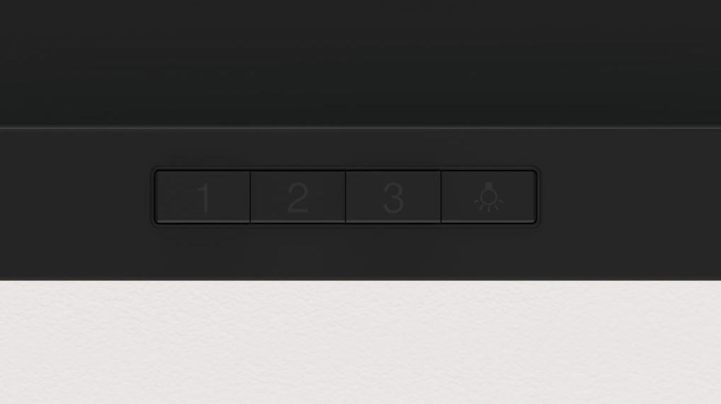 Primer plano de un panel con tres botones numerados y un icono de luz.