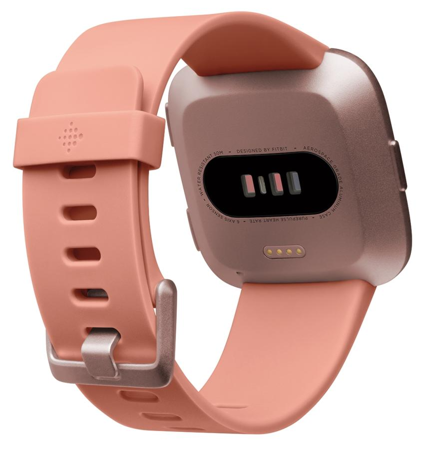 Primer plano de un reloj inteligente color melocotón con correa y hebilla; la parte trasera muestra sensores.