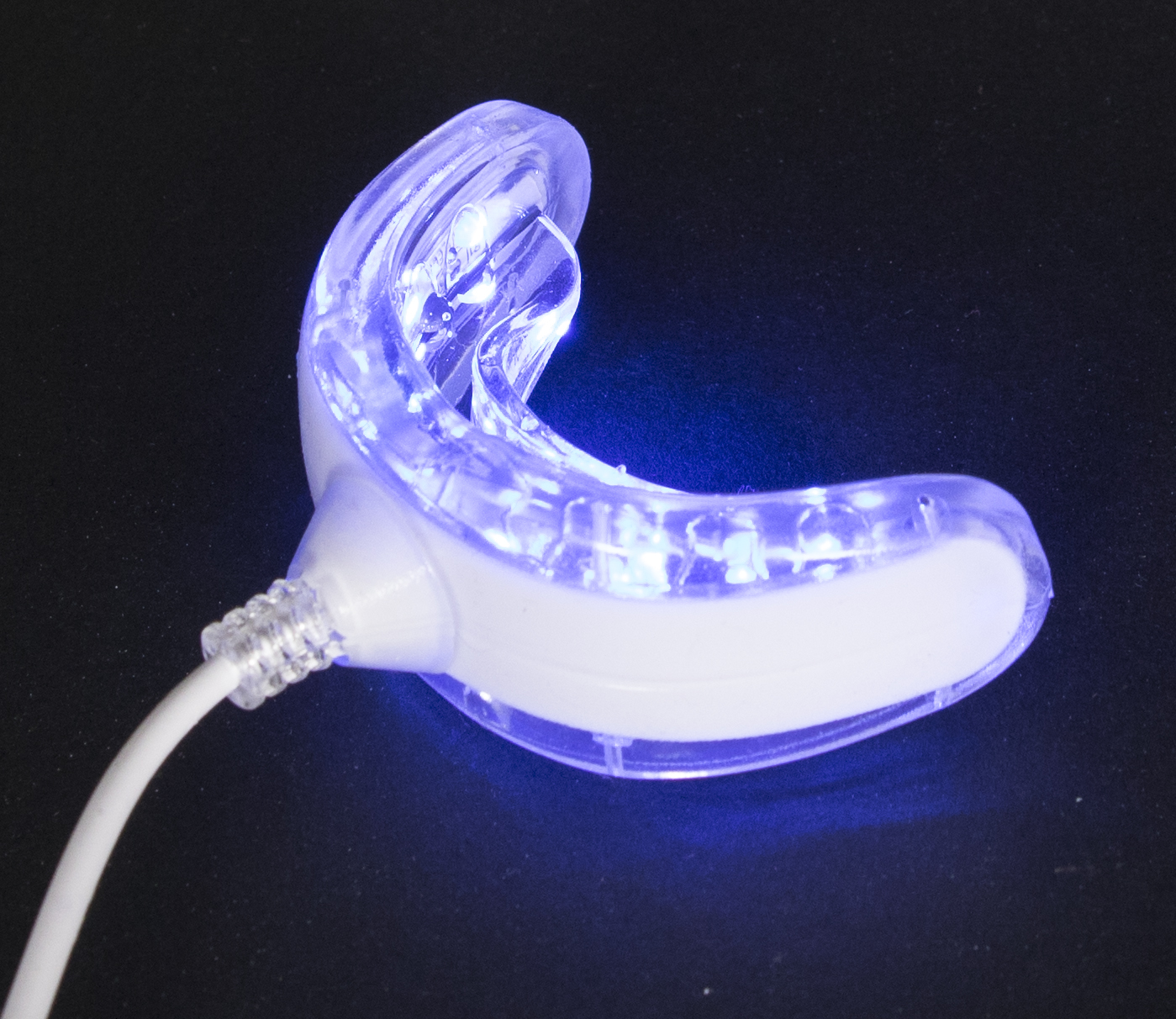 A blue light teeth whitening device on a black background.