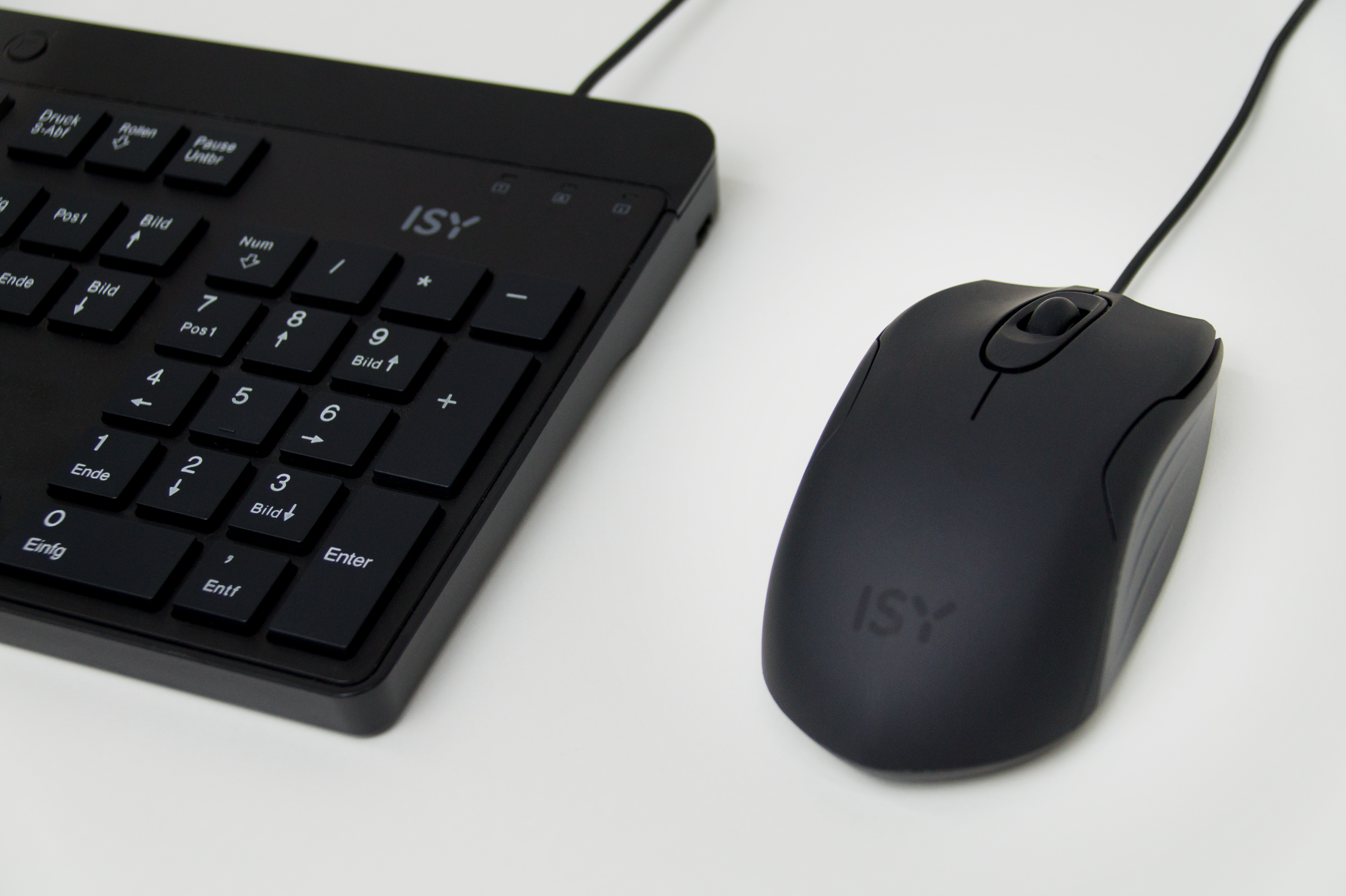 Schwarze ISY-Tastatur und -Maus auf weißer Oberfläche. Die Maus ist kabelgebunden und hat ein Scrollrad.