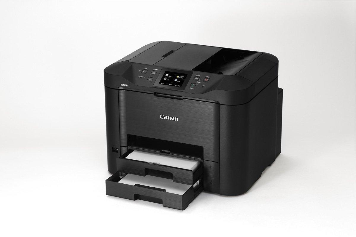 Una impresora Canon MAXIFY negra sobre fondo blanco. Las bandejas de papel están extendidas. La pantalla está encendida. El logotipo de Canon es visible.