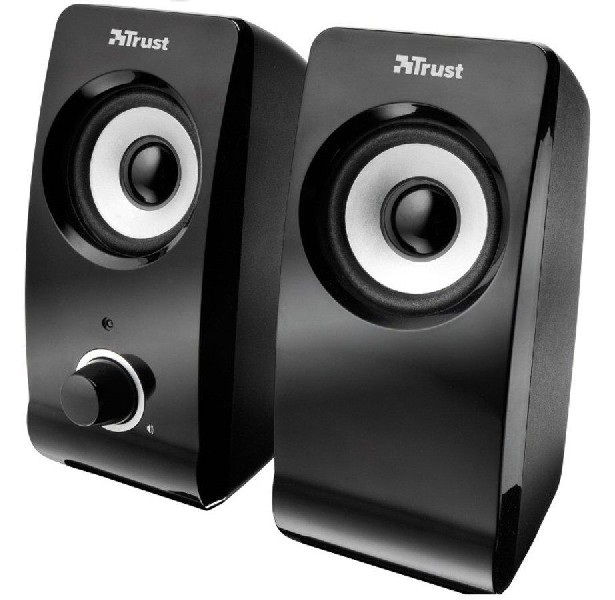 Dos altavoces de computadora Trust negros. Uno tiene una perilla de volumen. Fondo blanco.
