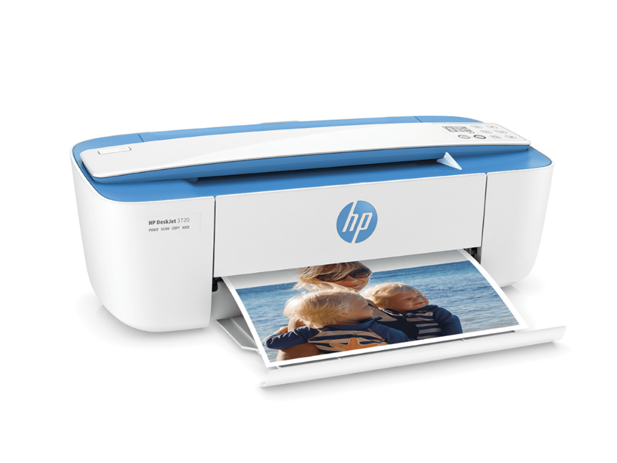 Una impresora HP blanca y azul está imprimiendo una foto de una familia. La impresora está sobre una superficie blanca.
