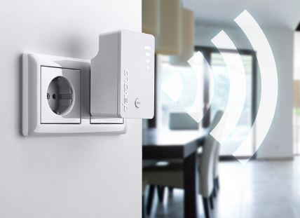 Extensor WiFi blanco enchufado a un enchufe de pared. Señal WiFi visible. Fondo interior.