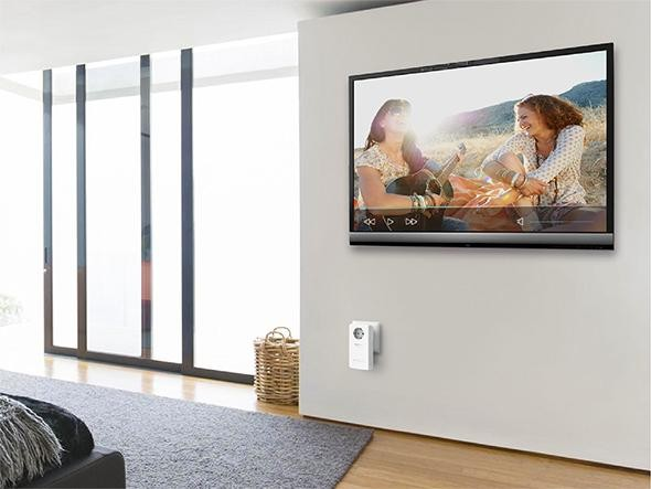 Una sala de estar con un televisor que muestra un video de dos mujeres y un dispositivo montado.