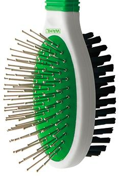 Un cepillo para mascotas Wahl blanco y verde sobre un fondo blanco.