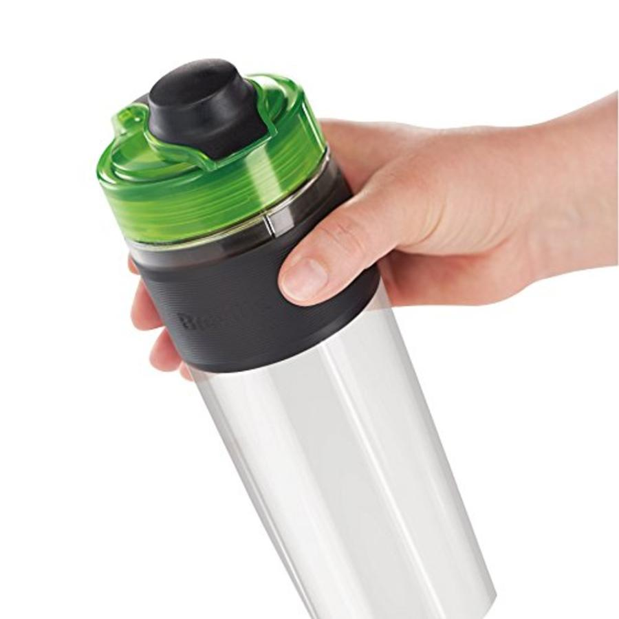 Una botella de agua transparente con una banda negra y una tapa verde sostenida por una mano.