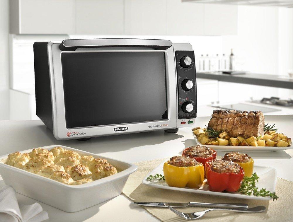 Un horno con platos de comida en una mesa. Incluye carne asada y pimientos rellenos.