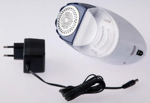 Un quitapelusas blanco y azul con un adaptador de corriente y cable negros sobre fondo blanco.