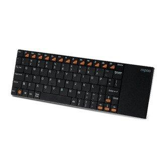 Teclado negro con teclas naranjas. Tiene un panel táctil en el lado derecho.
