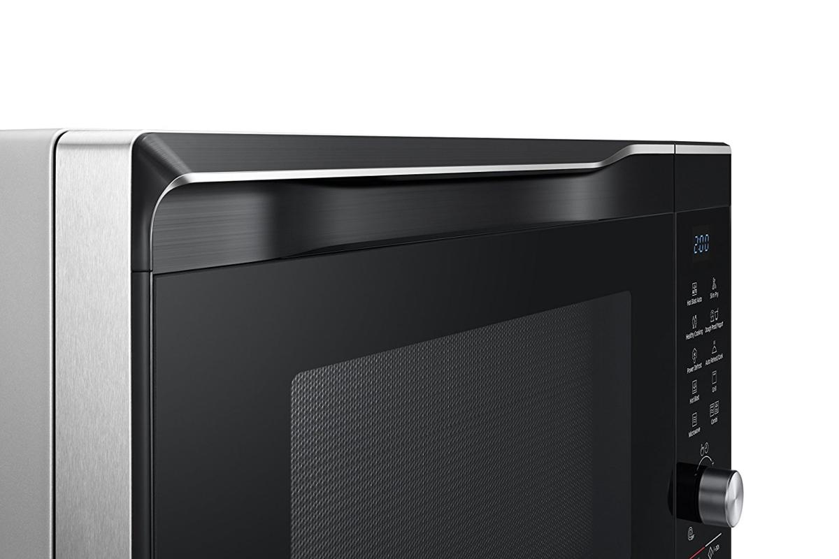 Vista de cerca de un horno microondas con puerta negra y detalles en acero inoxidable.