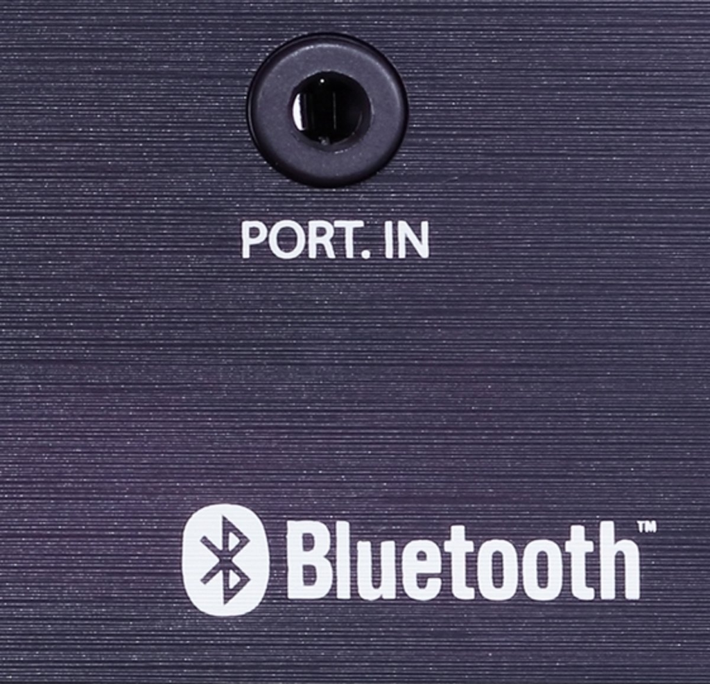 Egy fekete panel közelképe egy porttal és a PORT. IN szóval. Alatta a Bluetooth szimbólum és szó található.