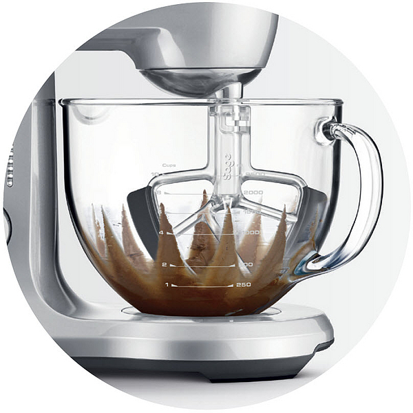 Silberner Mixer mit einer Glasschüssel mit brauner Substanz, Nahaufnahme.