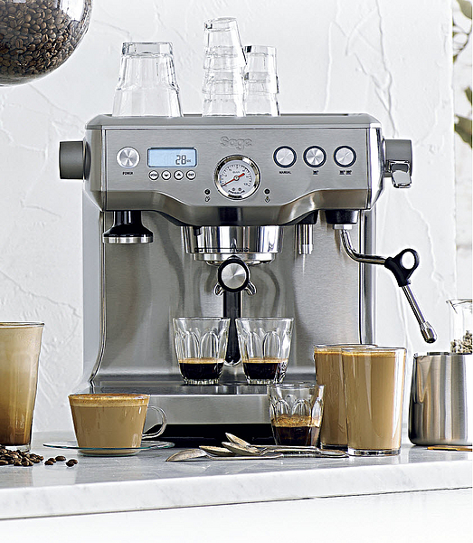 Silberne Espressomaschine mit zwei Espressi und Kaffeegetränken. Klare Gläser oben.