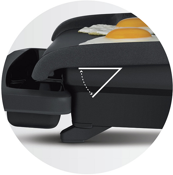 Eine Grillplatte, die Eier brät, schwarze Oberfläche, Eier obenauf, angewinkelte Ansicht.