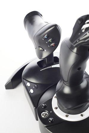 Joystick de juego negro. Dos palancas de control y varios botones. Fondo blanco.