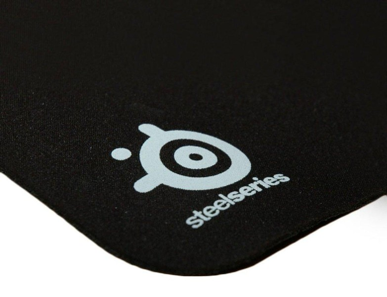 Alfombrilla de ratón negra con el logotipo de Steelseries en la esquina inferior derecha. Logotipo gris sobre fondo negro.