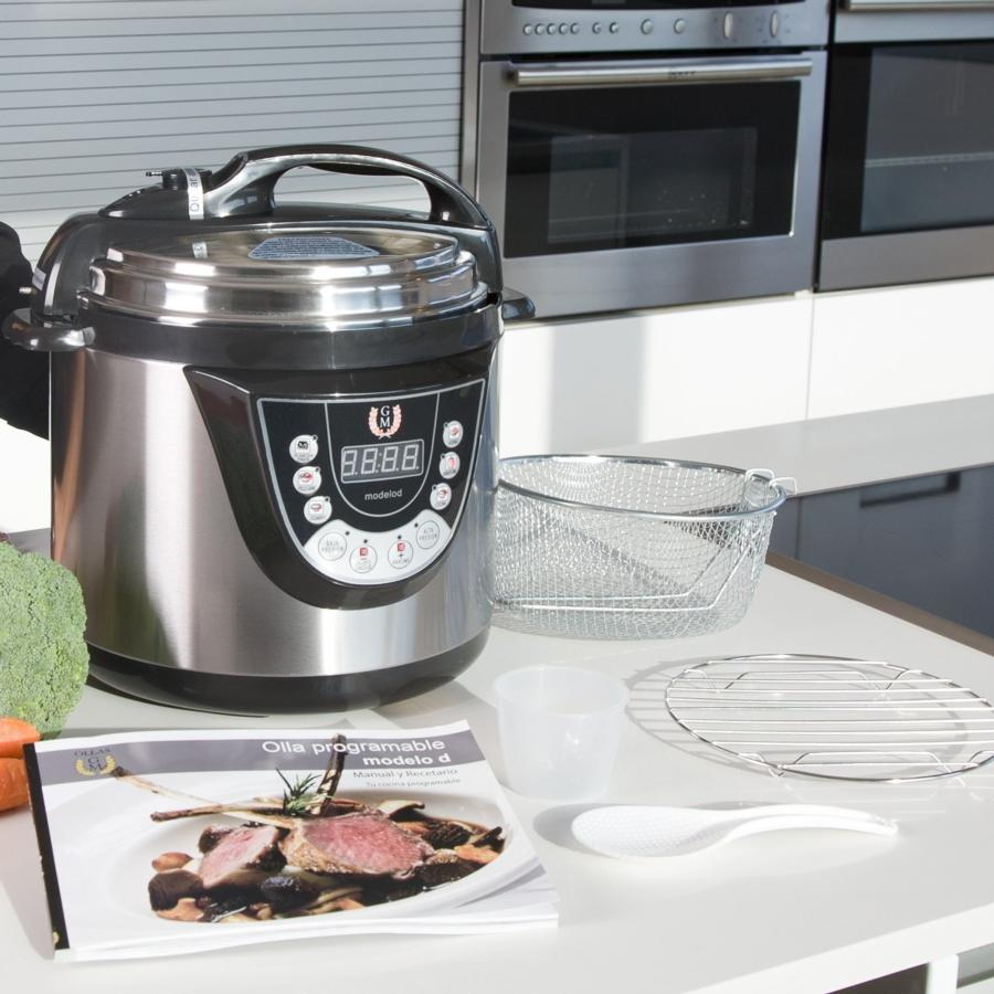 Olla a presión plateada y negra con accesorios, incluido un libro de recetas.