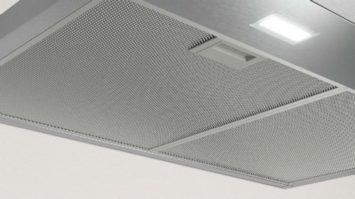 Campana extractora metálica de cocina, con rejilla y luz integrada.