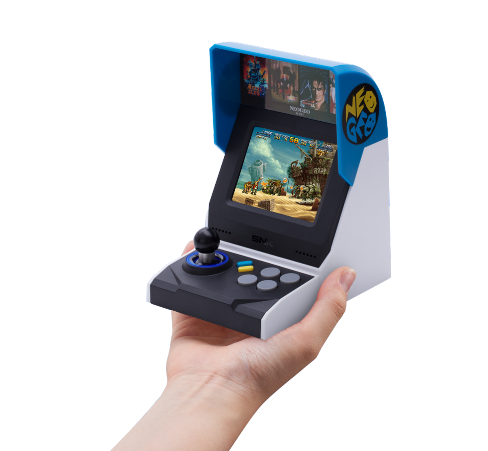 Una pequeña consola de juegos arcade en una mano, mostrando una pantalla de juego con múltiples personajes.
