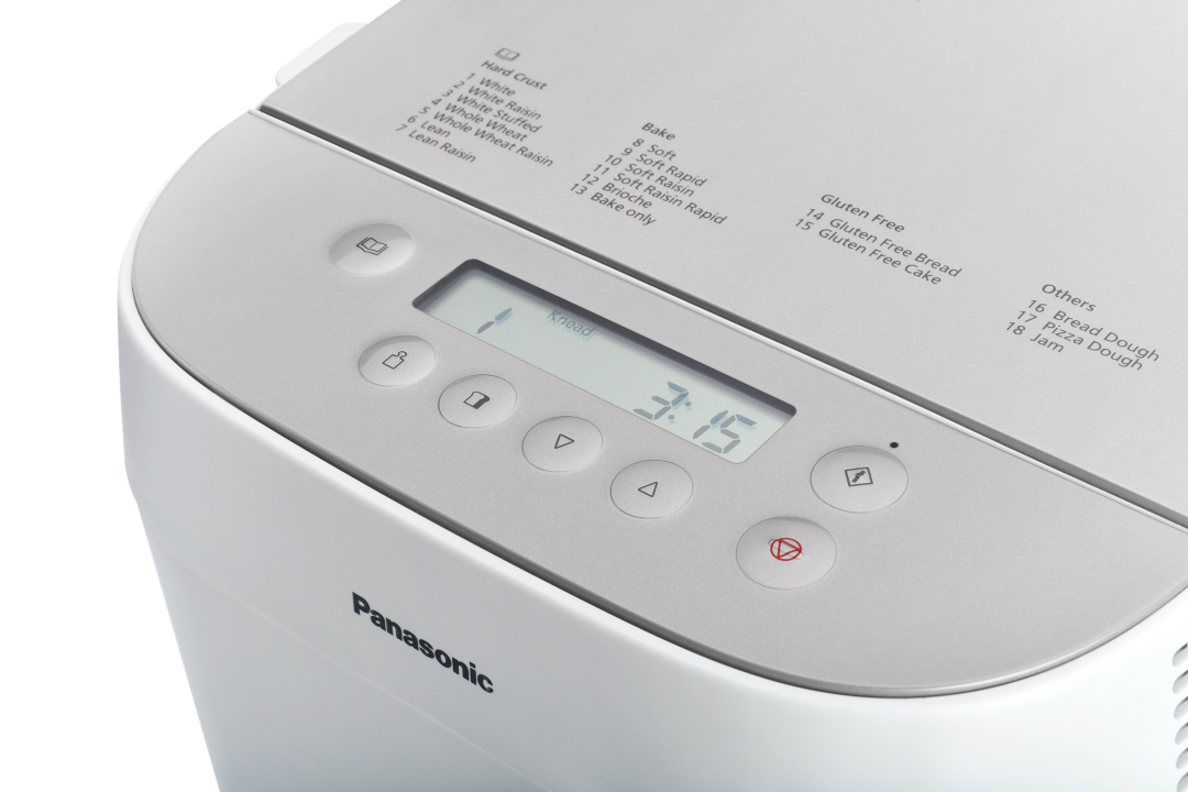Ein Panasonic Brotbackautomat mit Display, das Einstellungen zeigt. Die Maschine ist weiß.