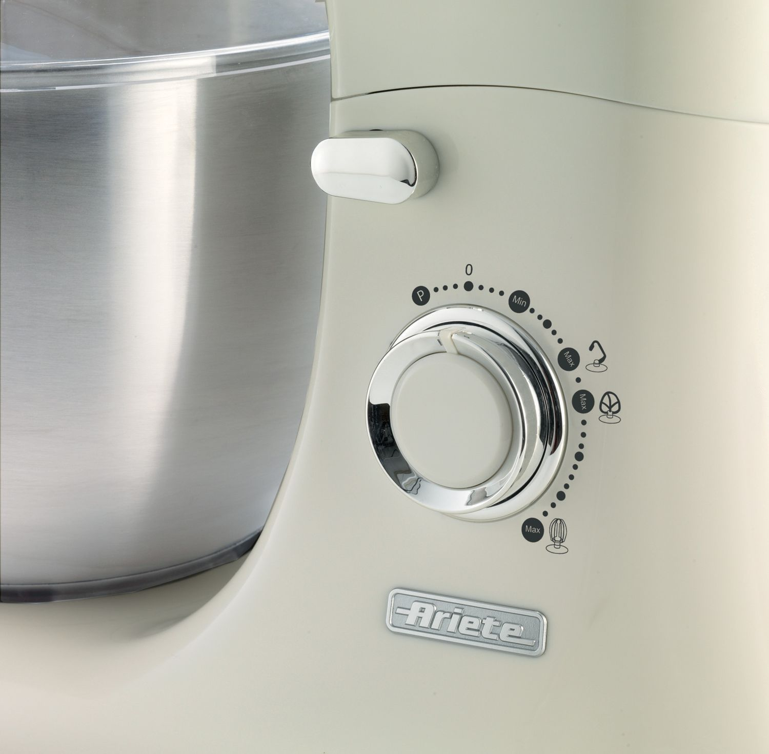 Krém színű konyhai mixer vezérlőpultjának közeli képe, fémtállal.