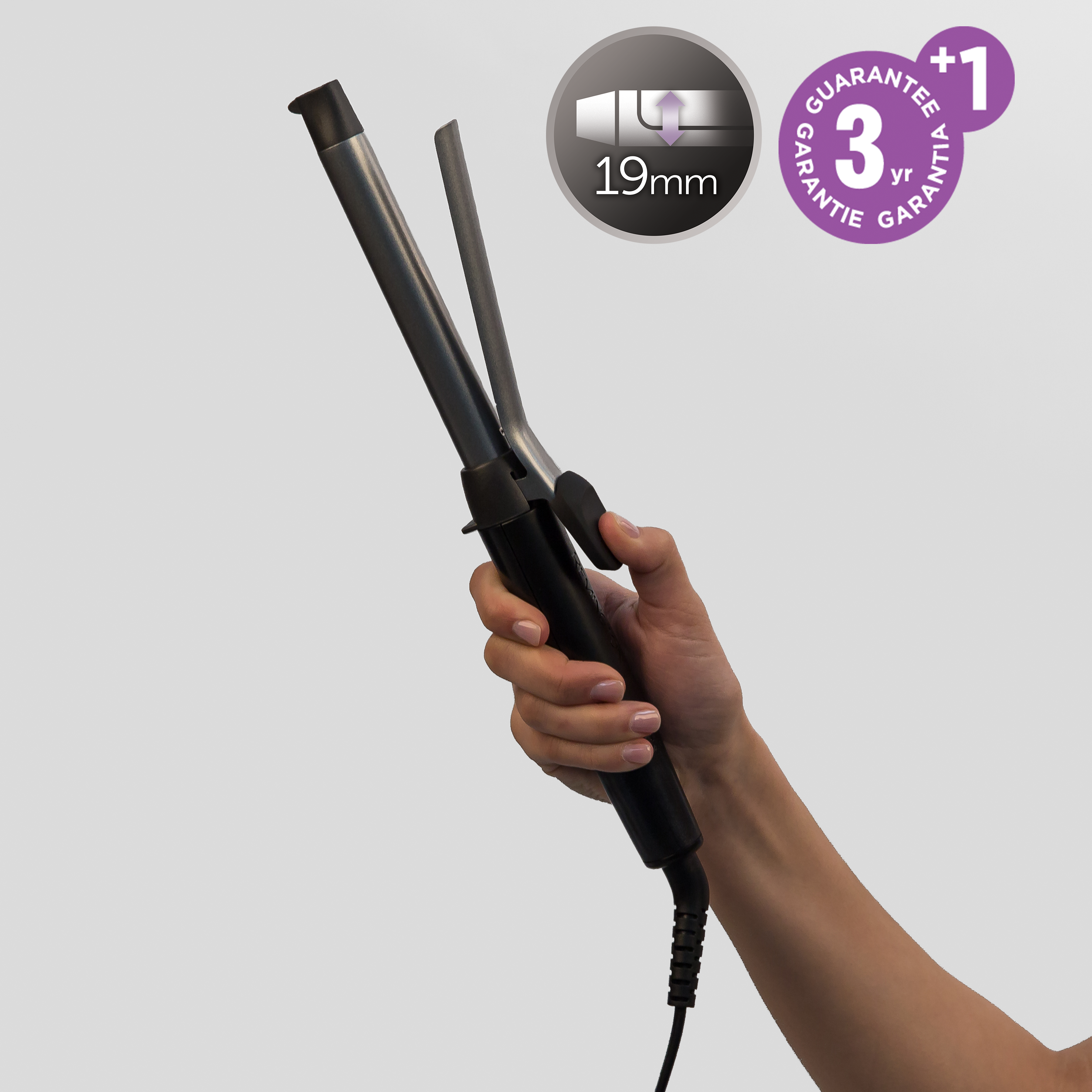 Hand holding a black curling iron. Silver heating element. Black handle. White background.