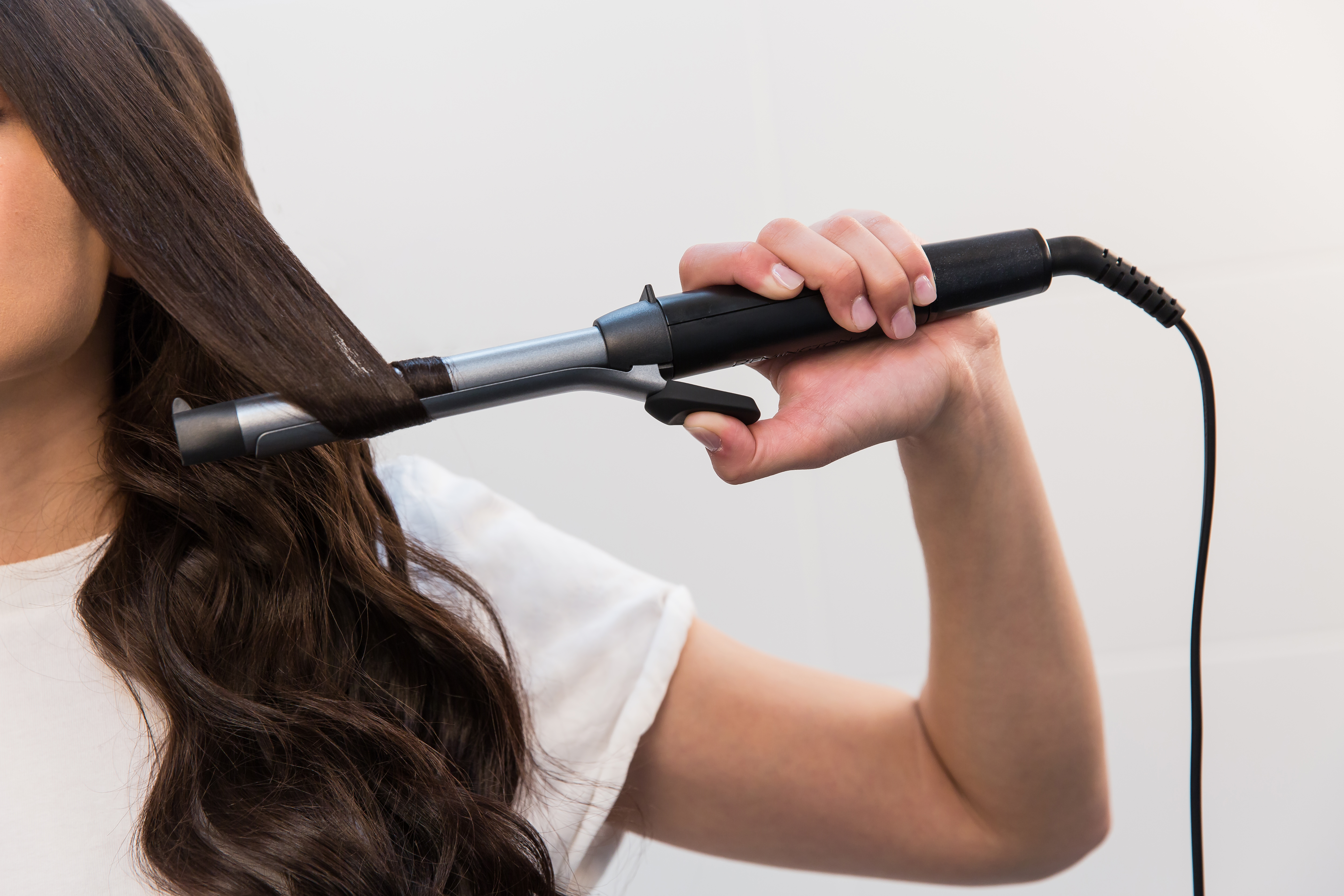 A white ring light on a black tripod stand, against a white background.