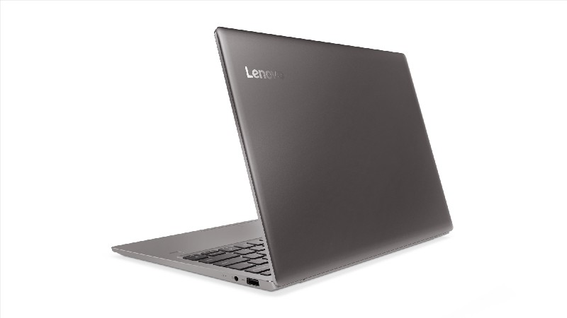 Un portátil Lenovo gris, ligeramente abierto, mostrando el teclado.