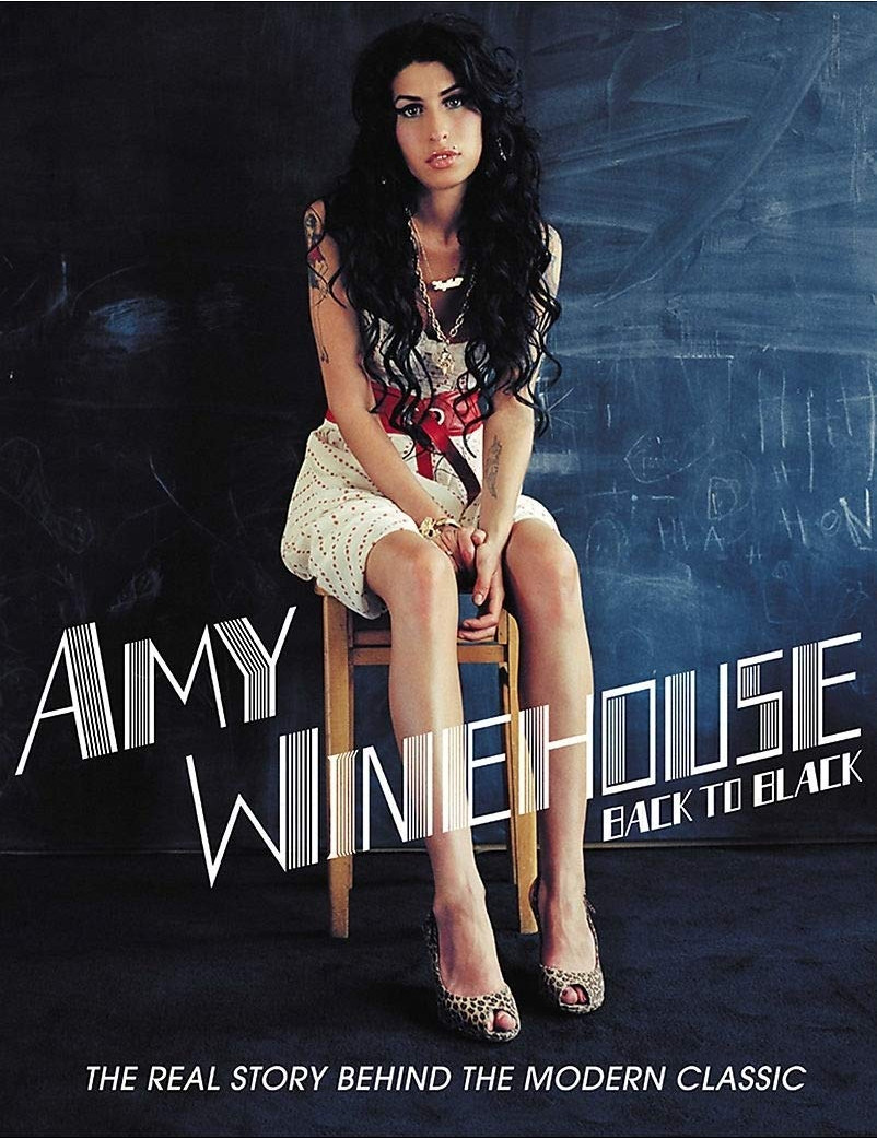 Pochette d'album d'Amy Winehouse : Amy assise sur une chaise, portant une robe blanche et des talons, posant.