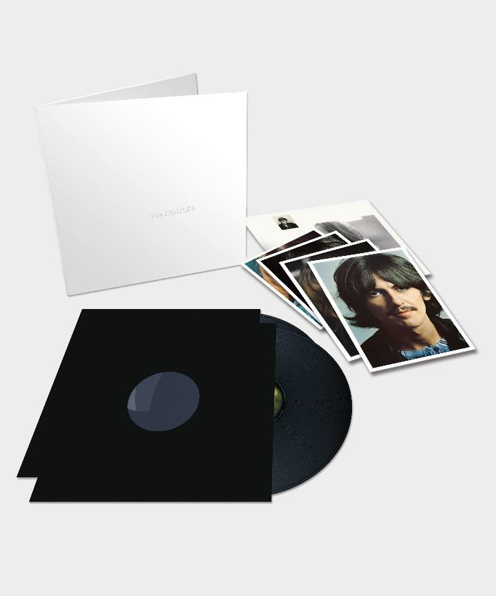 Een doos met een vinylplaat, wat foto's en een zwarte vinylplaat hoes.