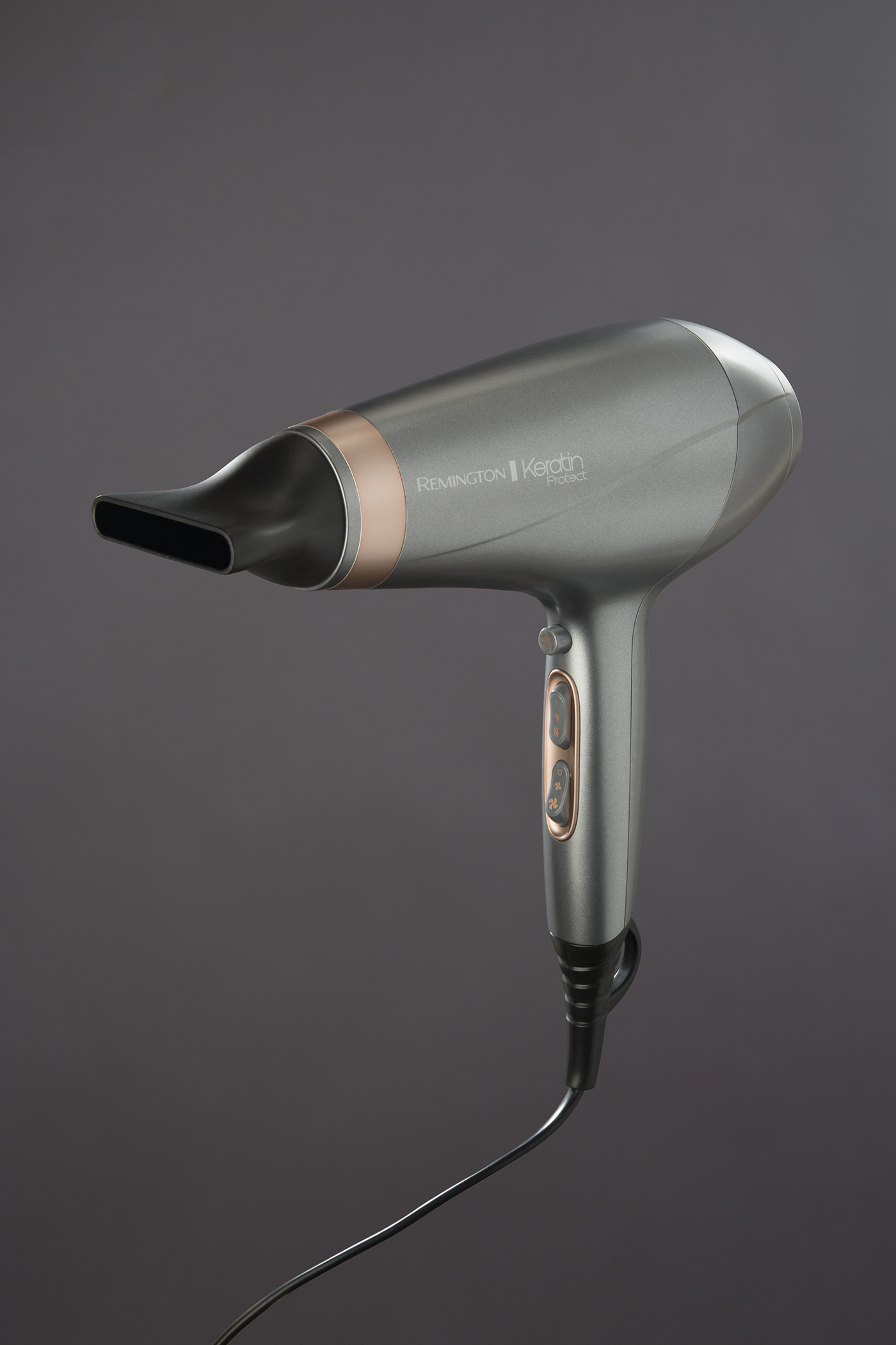 A gray Remington hair dryer with a black nozzle and handle, against a gray background.
