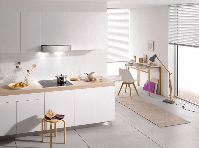 Cocina moderna con armarios blancos, encimera de madera y cocina.