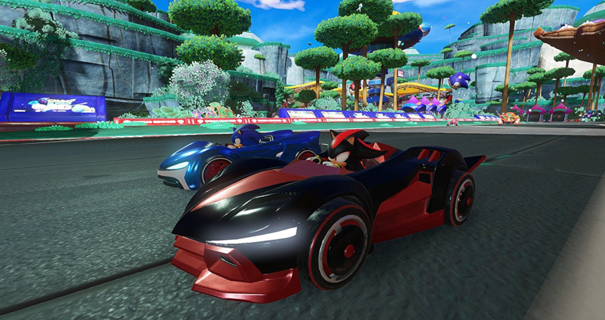 Deux voitures de course dans un jeu de karting, une bleue, une rouge, sur une piste colorée.