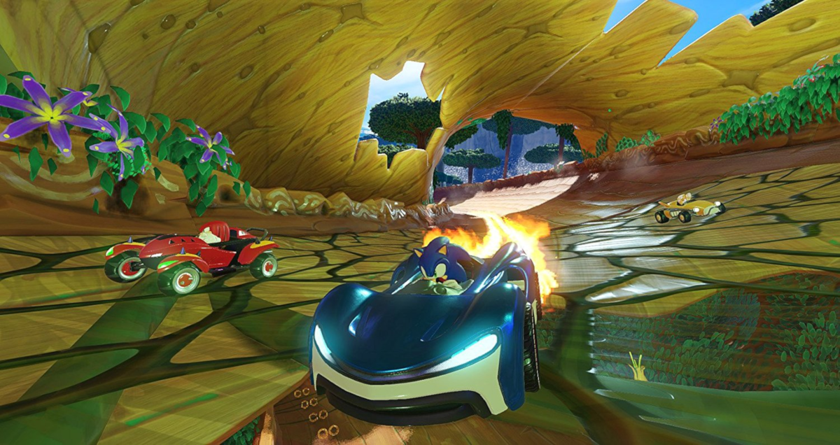 Une scène de course d'un jeu vidéo avec Sonic dans une voiture bleue, avec d'autres coureurs et une piste.