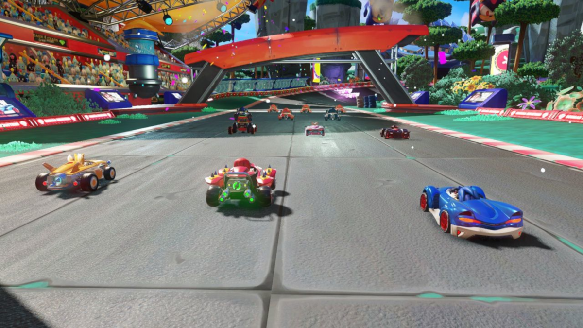 Scène de jeu de course de kart avec divers karts colorés courant sur une piste avec des spectateurs.