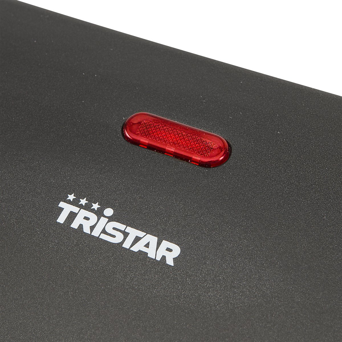 Close-up van een zwart oppervlak met een rood Tristar logo en rood licht.
